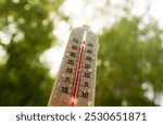 Thermometer for measuring outdoor air temperature. Tropical rain. Meteorological device for observing and measuring the weather. Weather forecast. Heavy rain in hot weather, drought in summer.