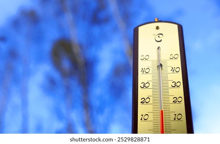 Thermometer for measuring outdoor air temperature. Cold weather in autumn season. Meteorological device for observing, measuring the weather. Weather forecast. Thermometer on blue sky background.  - Powered by Shutterstock