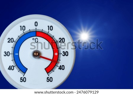 Thermometer over 30 degrees Celsius with sun in blue sky