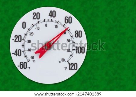 Thermometer at seventy degrees Fahrenheit on green for your summer or spring message