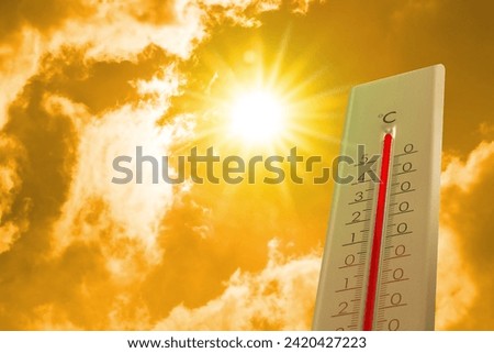 Thermometer showing high temperature against sky with clouds during very hot day in summer