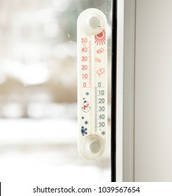 Thermometer Sitting On The Outside Of A Window Showing Seven Degree Celsius