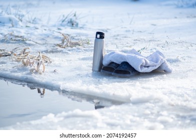 Thermos, Slippers And A Towel Near The Ice Hole. Winter Swimming. Hot Drink In Winter. Get Warm With Coffee. Ice And Snow.