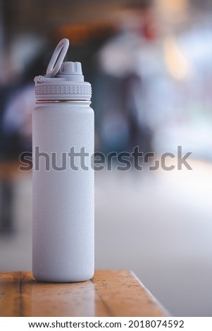 Thermos water bottle. Gray water bottle on bench at platform subway in Boston.