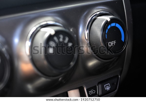 Thermostat and air conditioner fan speed dial\
on a car dashboard.
