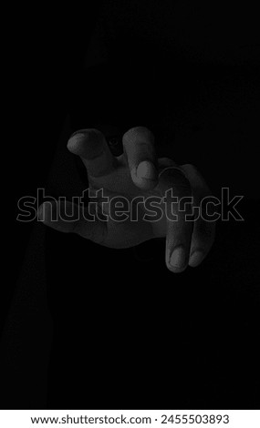 these low key image projects a eyes between the finger , antogonist looking for vengeance 
