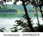 These are reflections reflected on the surface of the lake in the forest shining in the afternoon sun. Mountains and trees mingle with the lake to create a beautiful landscape.