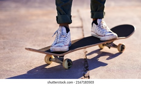 These sneakers were made for skating. A cropped shot of a woman standing on a skateboard. - Powered by Shutterstock