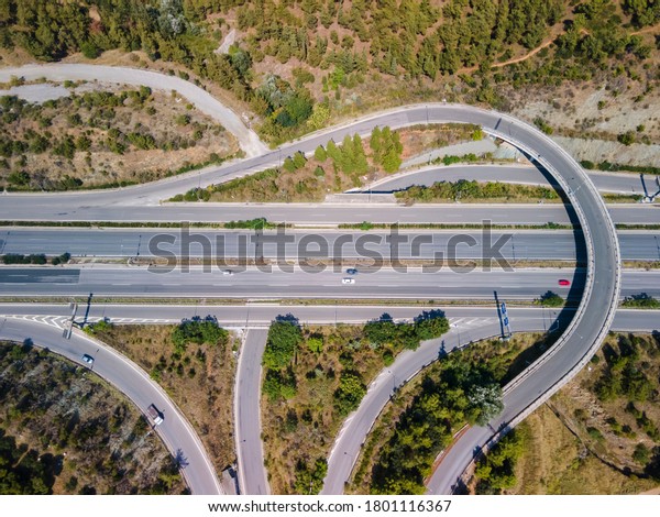 Thessaloniki, Greece aerial drone landscape of\
interchange traffic on Periferiaki inner ring road. Day top\
panorama of European multi-level stack highway junction with\
passing cars through\
forest.