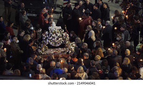 Thessaloniki, Greece - April 22 2022: Good Friday Orthodox Easter Epitaph procession. Crowd in the streets holding candles attends the commemoration of decorated with flowers Epitafios at night.