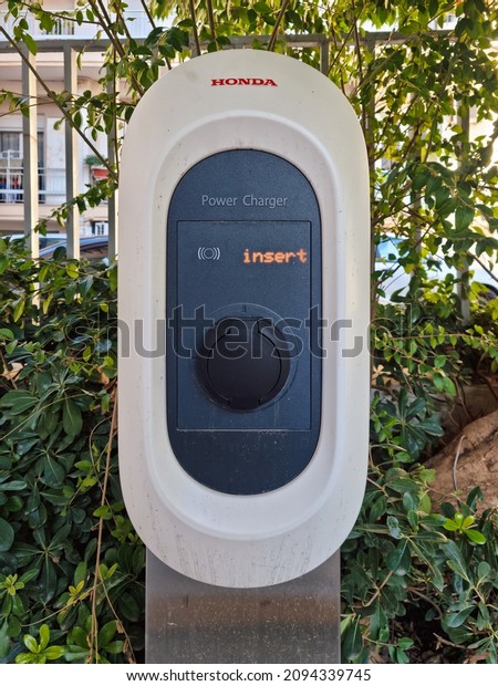 Thessaloniki, Greece - December 21 2021: Honda\
electric car power station with logo. Day view of Power Charger\
wall box point used to effortlessly supply green low-cost renewable\
energy to\
vehicles.