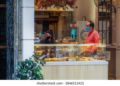 Thessaloniki, Greece - November 02 2020: People At Shop Entrance With Covid-19 Masks. Food Store With Clerk Wearing Protective Mask Serves Customer With Face Protection To Prevent Coronavirus Spread.