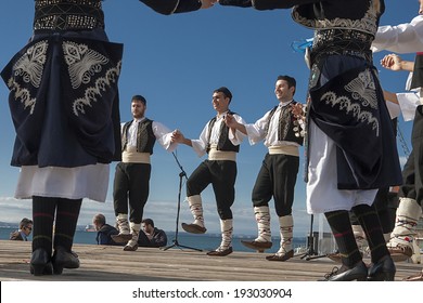 THESSALONIKI, GREECE, OCTOBER 2, 2013: Olympic flame holder ceremony. Group performing Greek folklore dance.