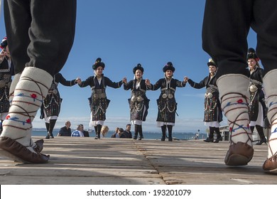 THESSALONIKI, GREECE, OCTOBER 2, 2013: Olympic flame holder ceremony. Group performing Greek folklore dance.