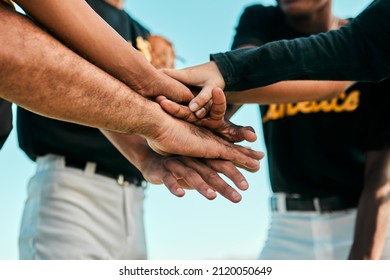 They all work together for a single purpose. Shot of a team of young baseball players joining their hands together in a huddle during a game. - Powered by Shutterstock