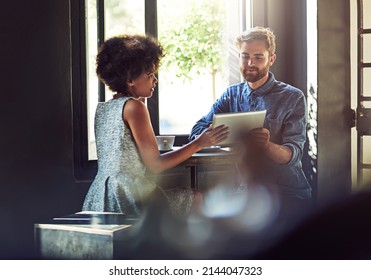 They Come Here For The Fast Internet And Friendly Service. Shot Of Two People Using A Digital Tablet In A Cafe.