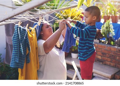 They Enjoy Spending Quality Time Together. Shot Of A Mother And Son Hanging Laundry On A Washing Line Outside.