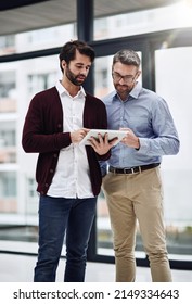 They Have All The Help They Need With Technology. Cropped Shot Of A Businessman Showing Something To His Colleague On His Tablet In The Office.