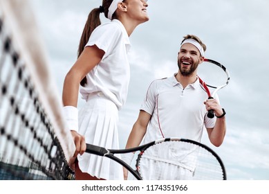 They play like a team. Beautiful young woman and man holding tennis racket and discussing set - Powered by Shutterstock