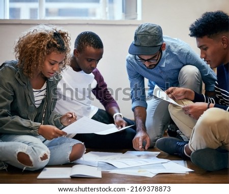 They putting in the work together. Cropped shot of university students working together on the floor in class.