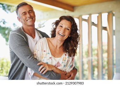 They Share A Sense Of Humor. An Loving Mature Man Embracing His Wife With A Smile.