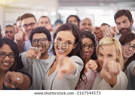 They want you on their team. Portrait of a group of smiling businesspeople pointing at the camera.