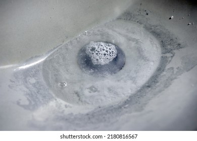 They wash their hands in the sink, the sewer pipe of which is clogged. - Shutterstock ID 2180816567