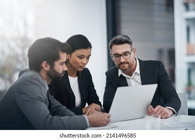 Theyre a team that gets things done. Shot of three businesspeople gathered around a laptop in the boardroom. - Shutterstock ID 2141496585