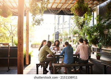 Theyre working out in the fresh air today. Shot of a group of designers having a meeting at a coffee shop. - Powered by Shutterstock