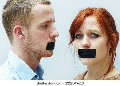 Theyve been silenced. A young couple looking sad with tape over their mouths. - Powered by Shutterstock