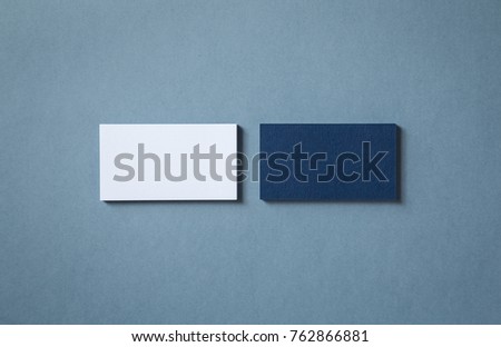 Thick blank double-sided business cards with textured surface stacked up on a grey background