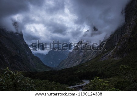 Thick clouds floating over mountain ridge and amazing valley on South Island of New Zealand