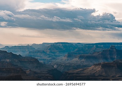 Thick clouds stretch across the sky above the dramatic depths of the Grand Canyon.