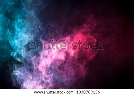 Thick colorful smoke of blue, pink, red on a black isolated background. Background from the smoke of vape