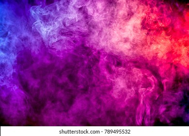 Thick Colorful Smoke Of Purple, Pink, Red On A Black Isolated Background. Background From The Smoke Of Vape