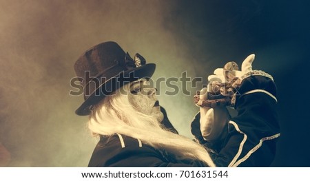 Thick crazy actor in white makeup with a snake.