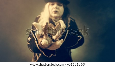 Thick crazy actor in white makeup with a snake.