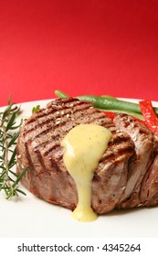 Thick Filet Mignon With Bearnaise Sauce, Green Beans And Red Peppers, And A Sprig Of Rosemary.  Red Background.