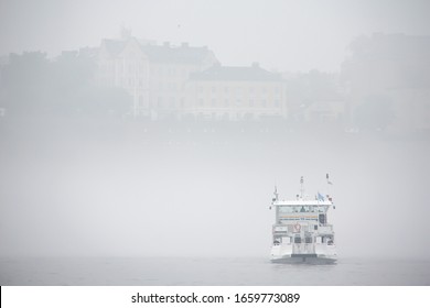 A Thick Fog Over A Baltic Sea In Stockholm In The Afternoon In June With Södermalm In The Background And A Contour Of A Ferry Obscured By The Fog.
