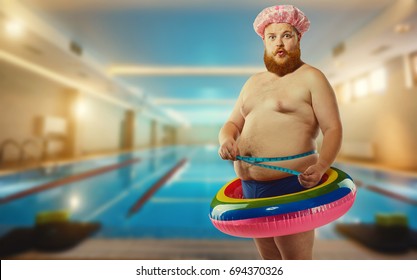 Thick funny man in the inflatable circle in the pool