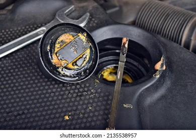 The Thick, Greasy Yellow Motor Oil Under Oil Cap As Signs And Symptom Of A Blown Head Gasket. Broken A Car