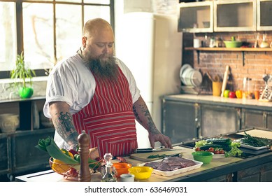 Thick guy preparing food in kitchen