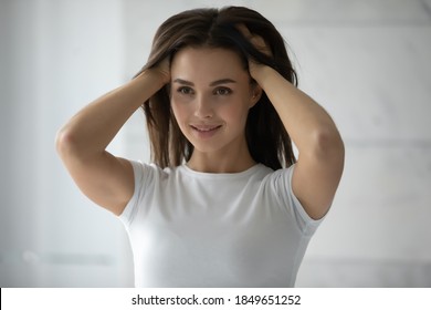 Thick And Healthy. Long-haired Millennial Woman Standing By Mirror Burying Hands To Her Lovely Shiny Hair, Female Client Is Satisfied By Result Of Regular Use Of Professional Beauty Haircare Products