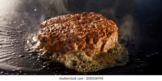 A Thick Juicy Minced Beef Patty For A Traditional Burger Grilling On A Griddle