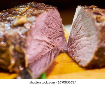 Thick Juicy Piece Of Beef Meat Steak Filet Mignon In Spices Pepper Garlic Rosemary Sliced In Two Pieces On A Wooden Board Closeup Macro With Bokeh