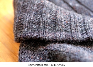 a thick knitted cardigan or sweater in brown on the floor.Close up