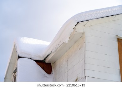 Thick Layer Of Heavy Snow Drift On Roof Of Farmhouse