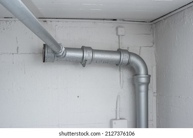 Thick Plastic Plumbing Twisting Tubes  Inside Communal Laundry Room Inside Apartment Building. No People..