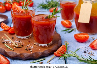 Thick red juice in glass with vegetables and spices on a wooden background. Selective focus.