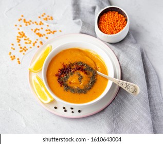 Thick red lentil soup served with lemon, dried mint and paprika. Turkish and Indian cuisine. Top view